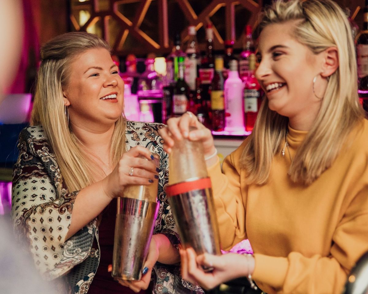 Two ladies shaking cocktails during a cocktail workshop by Classbento