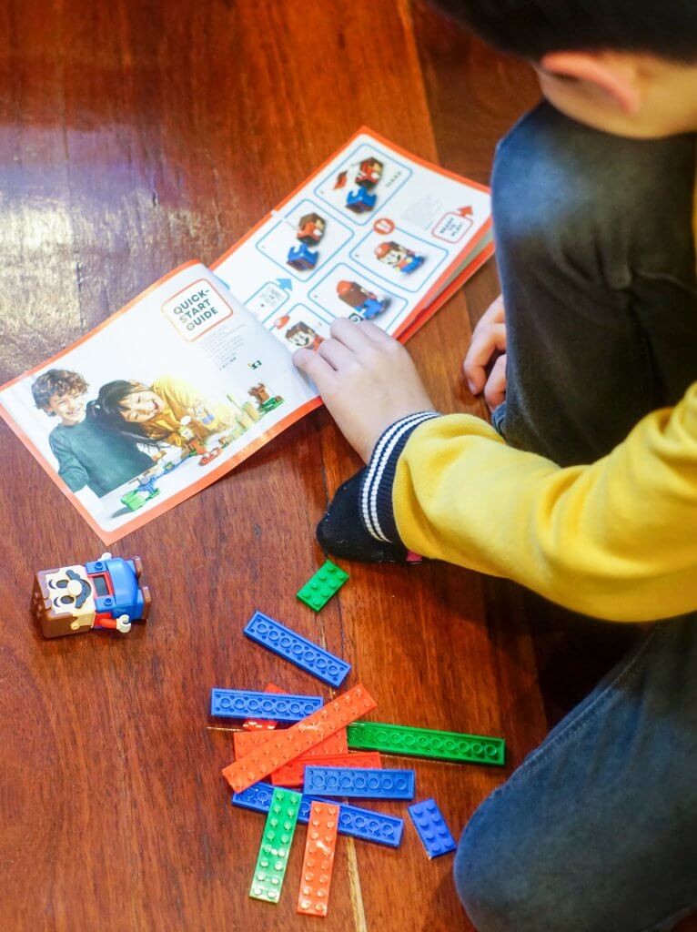 Child building LEGO Mario figure